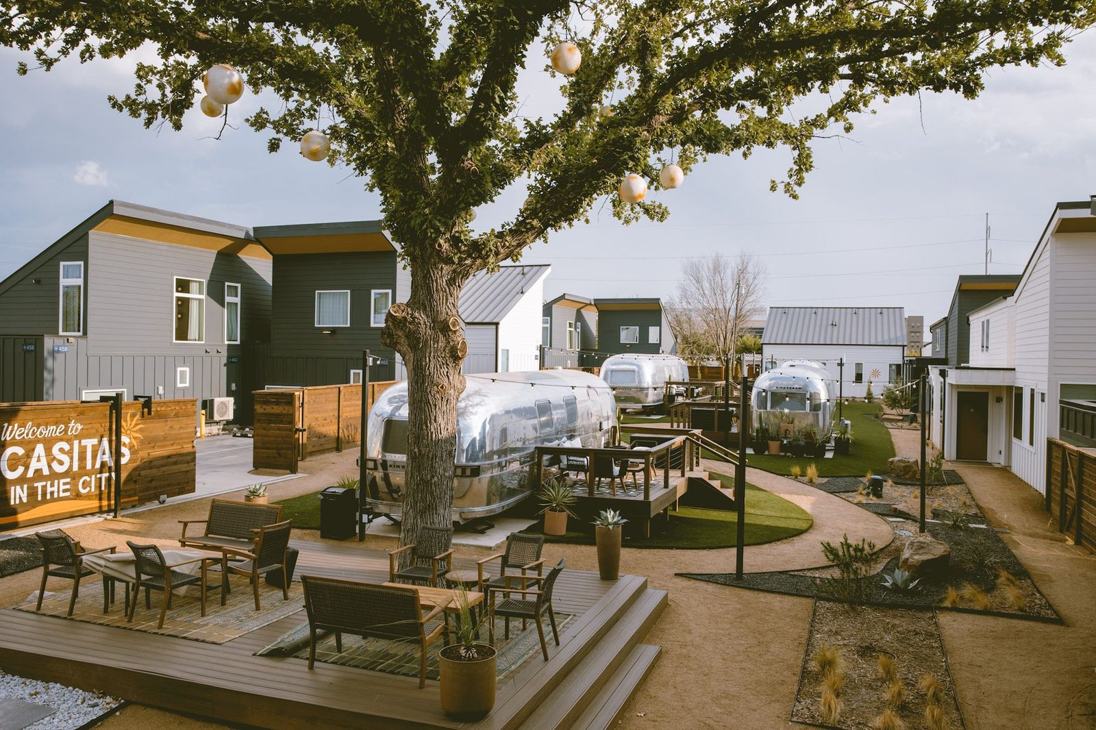 The gated Hotel SOMA courtyard in daylight, with Airstream suites, lawn paths and the Casitas in the City sign
